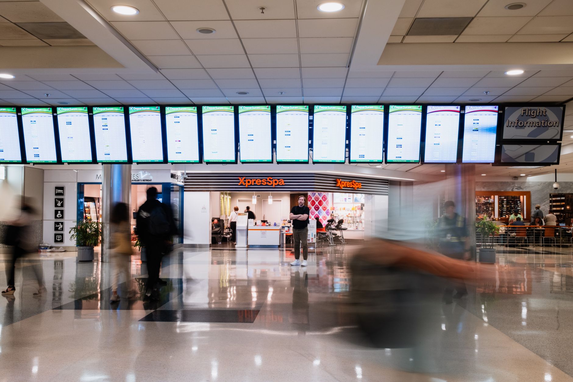 A coordinated row of digital information displays in a busy terminal